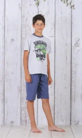 a boy standing in front of a white wood wall