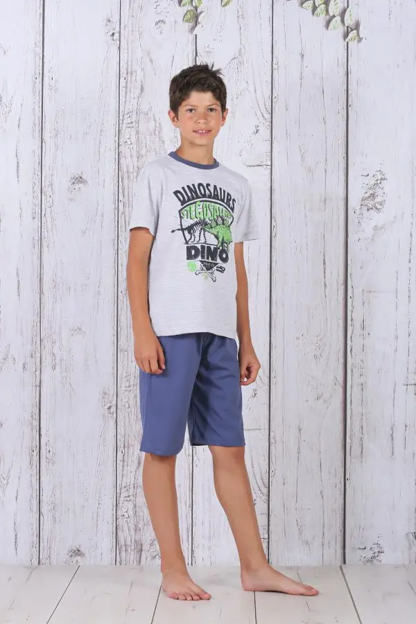 a boy standing in front of a white wood wall